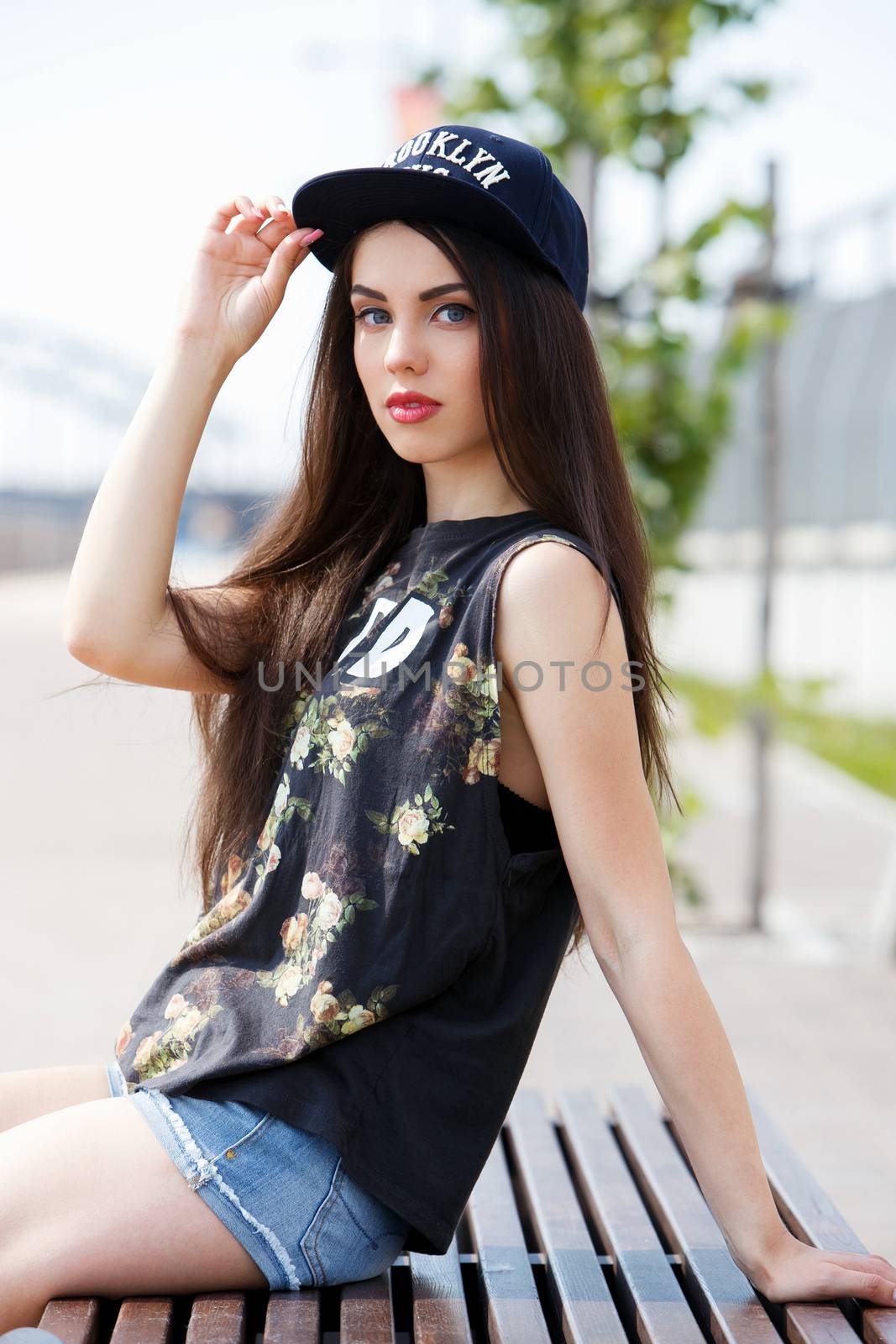 Street, outdoor. Attractive teen in a cap