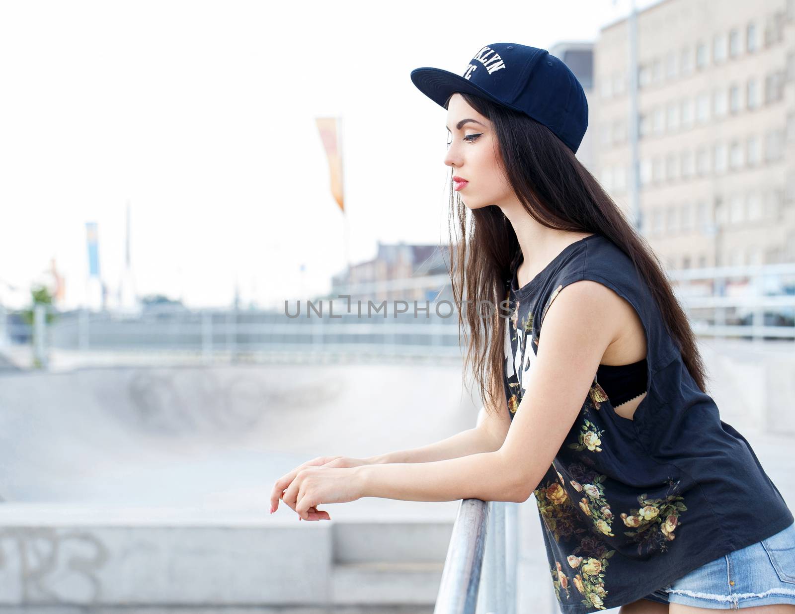 Street, outdoor. Attractive teen in a cap