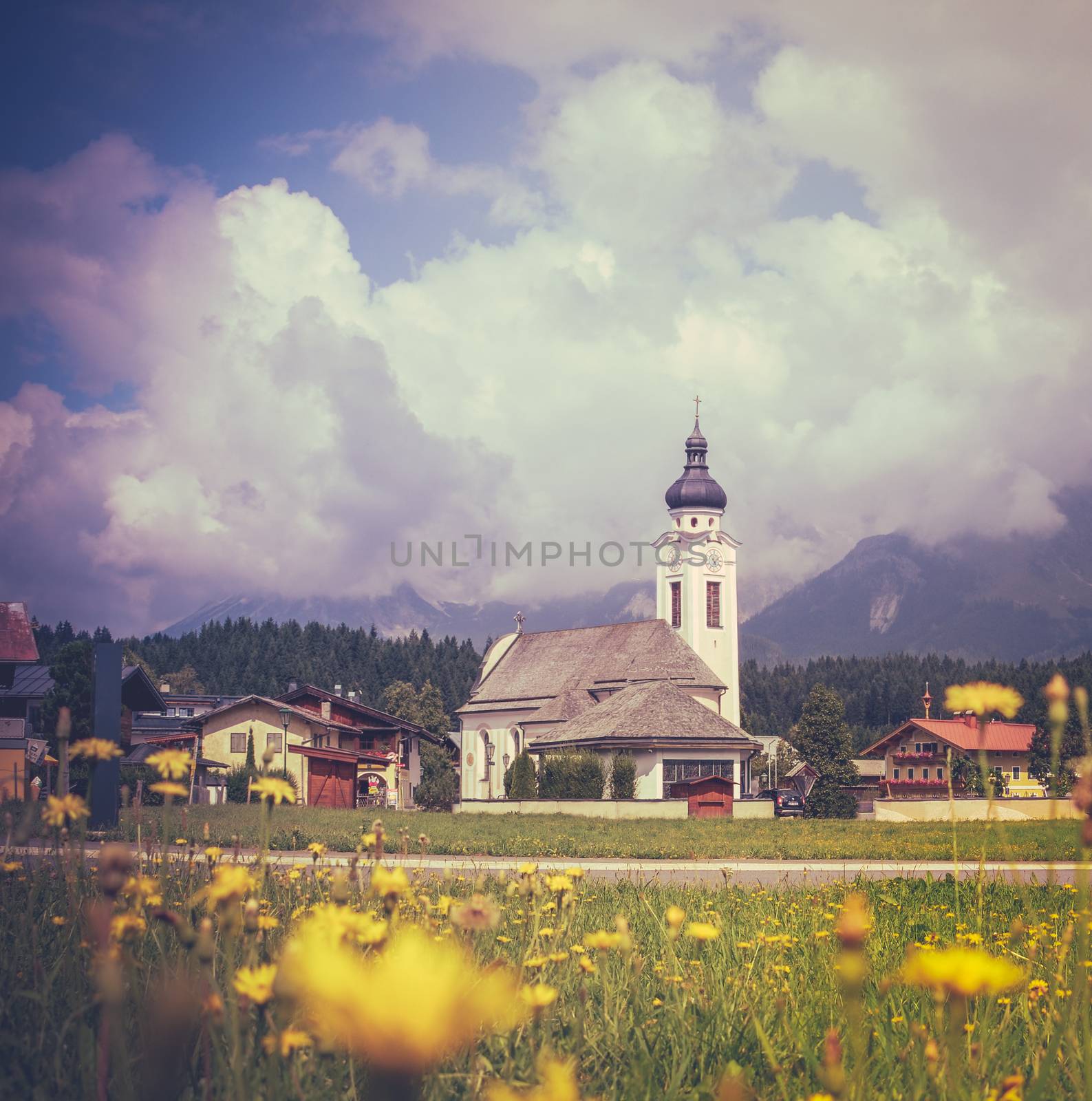 Retro Style VIntage Photo Of An Alpine Village And Meadow