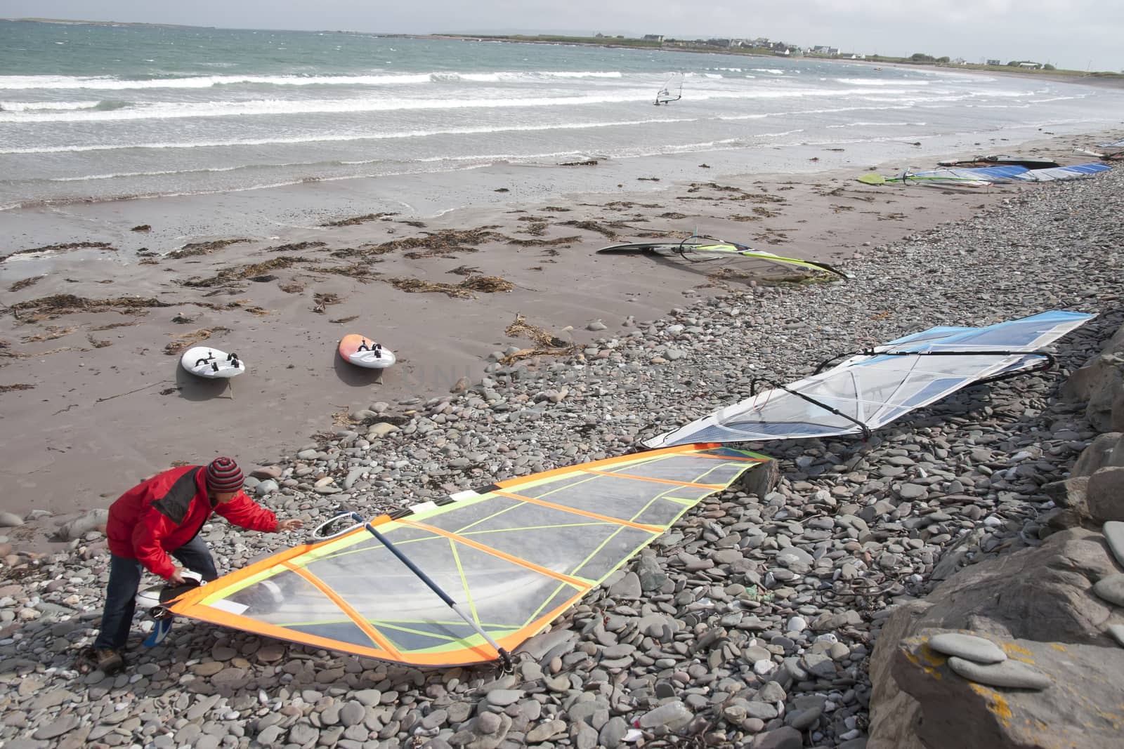 windsurfer getting equipment ready on the beach in the maharees county kerry ireland