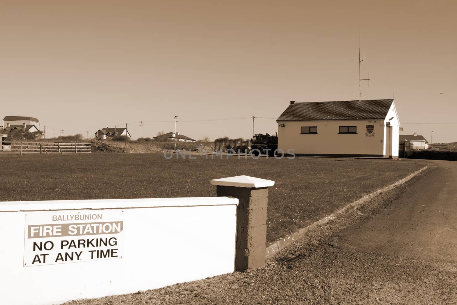 Ballybunion fire station with fire truck parked outside in sepia