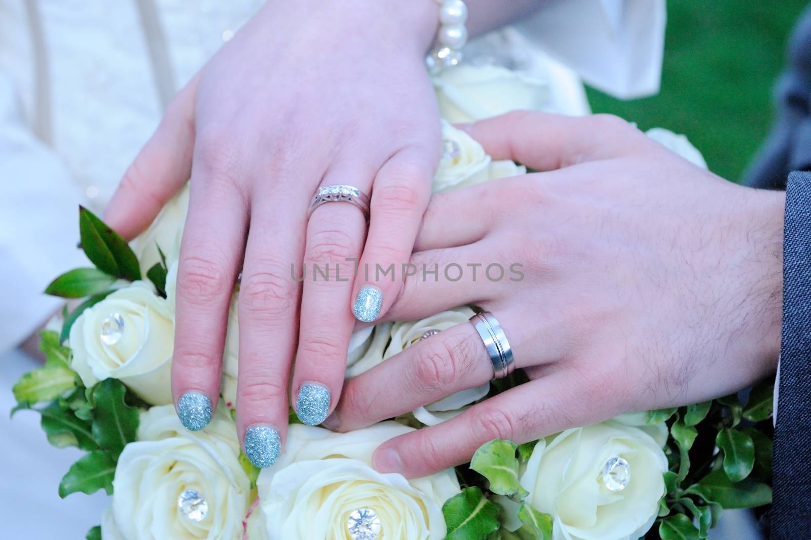 Close-up of bride and grooms hands on wedding day showing ring detail