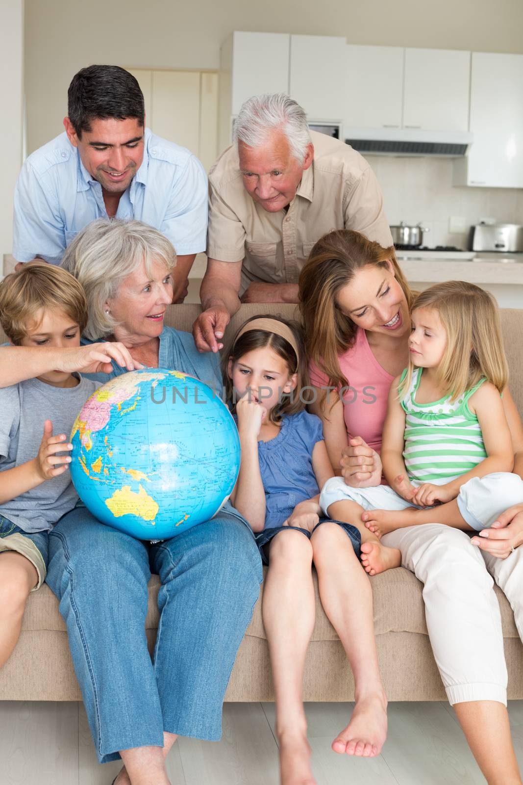 Family exploring globe in living room by Wavebreakmedia