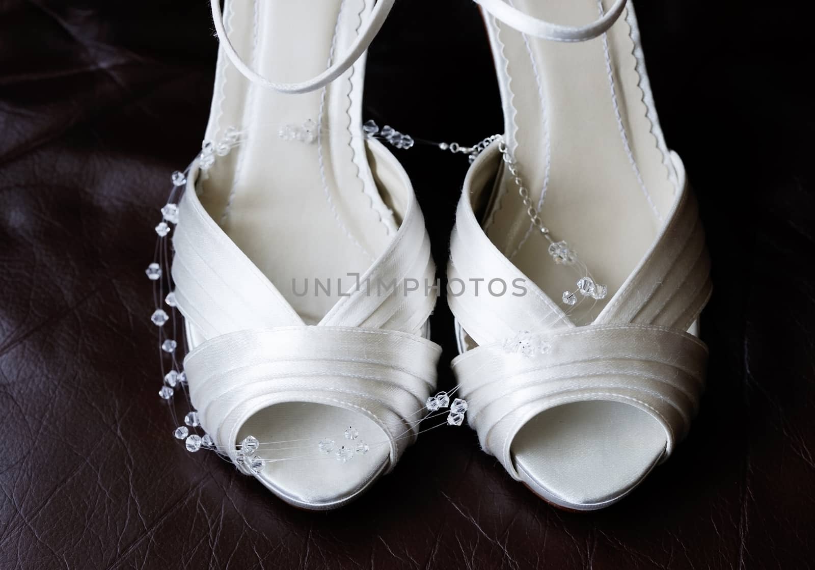 Closeup detail of brides shoes and necklace on wedding day