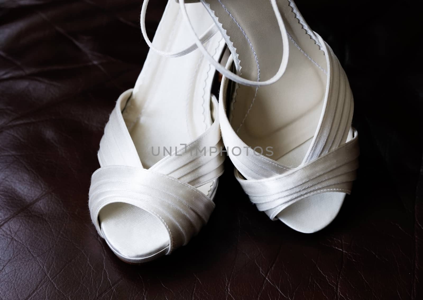 Closeup detail of brides white shoes on wedding day