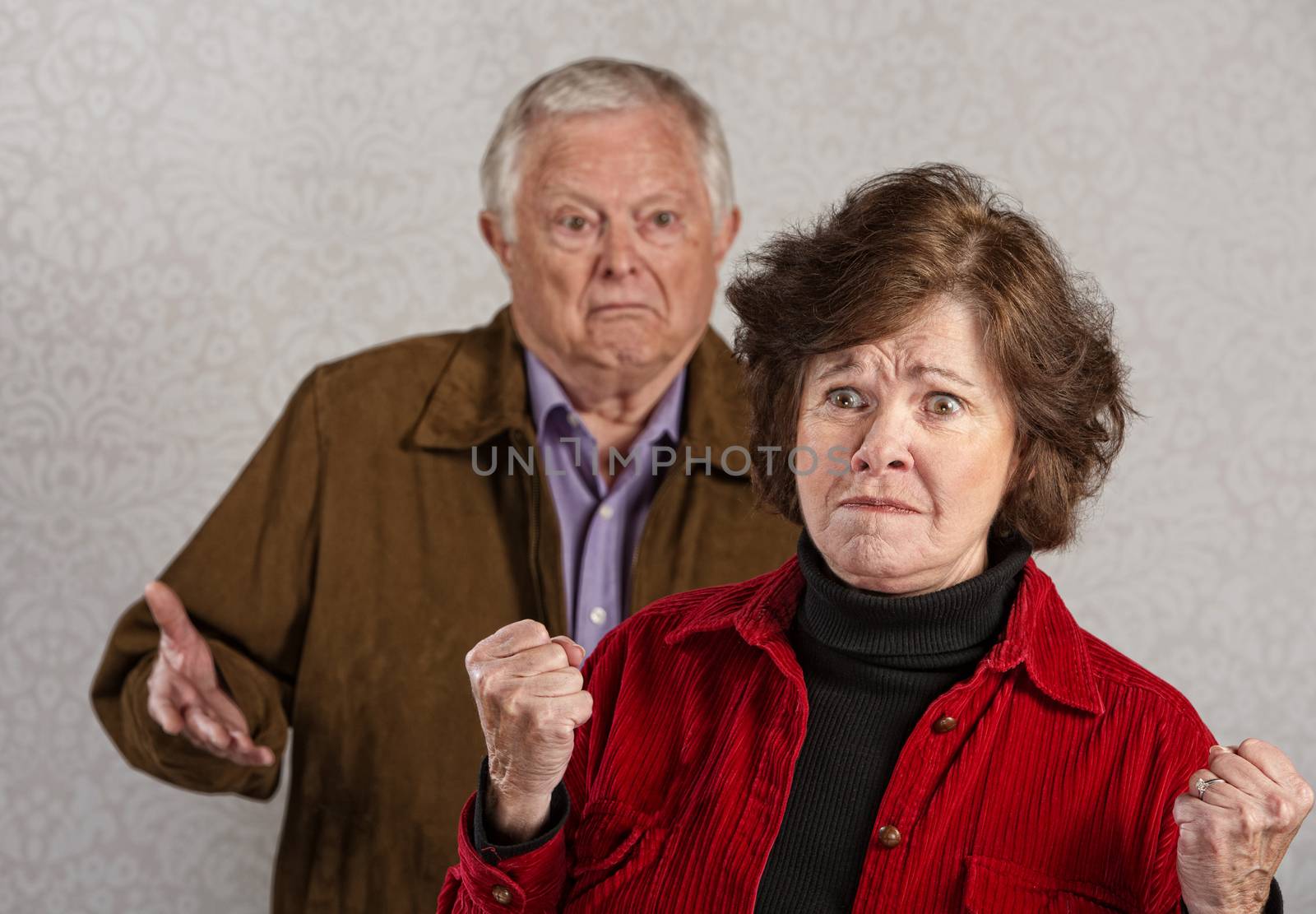 Offended mature wife near frustrated husband with hands up