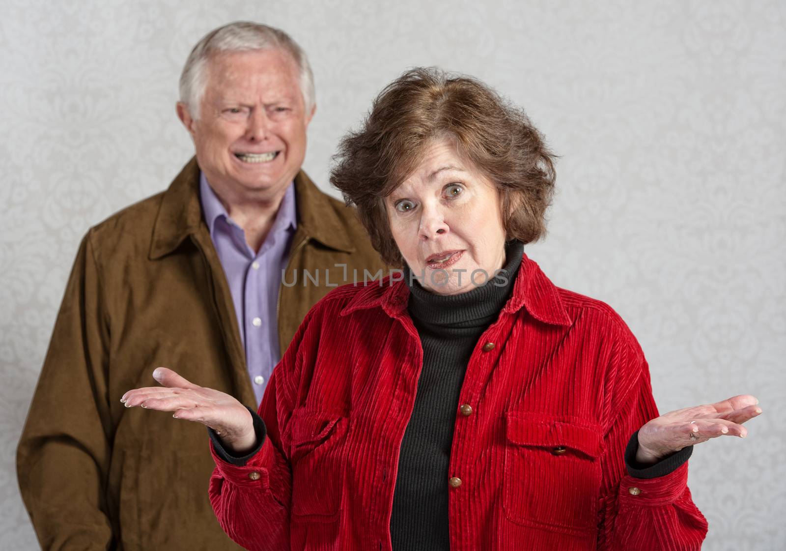 Frustrated woman with hands up and angry man
