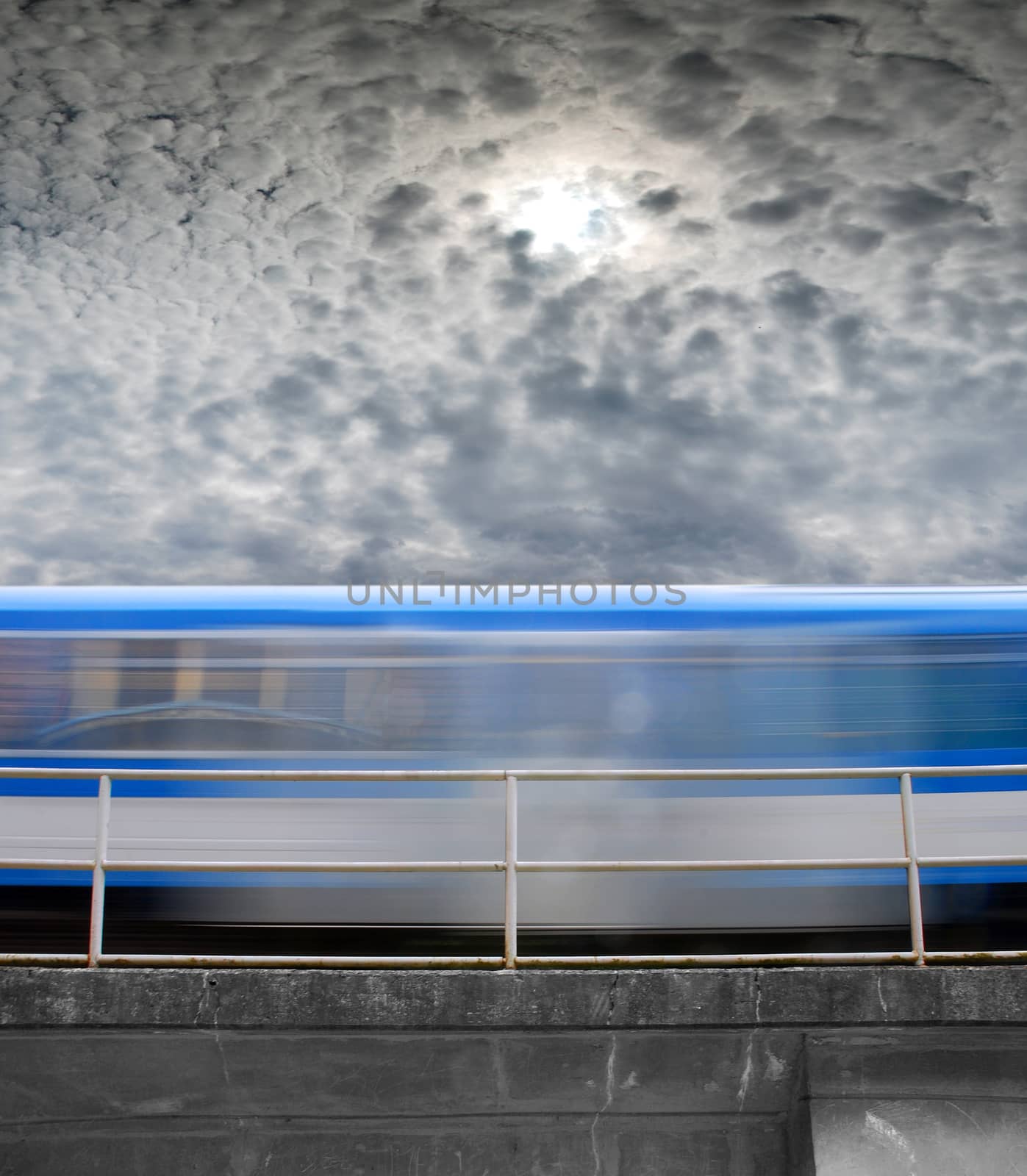 speeding train, a blurred line under gray skies