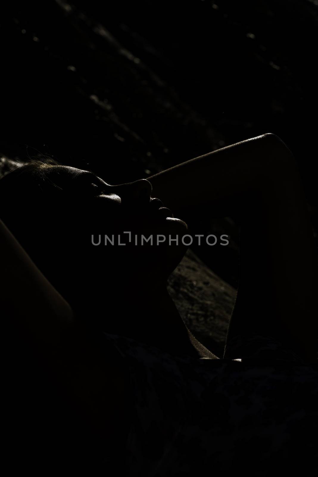 Lady sunbathing on a sunny day, low key image