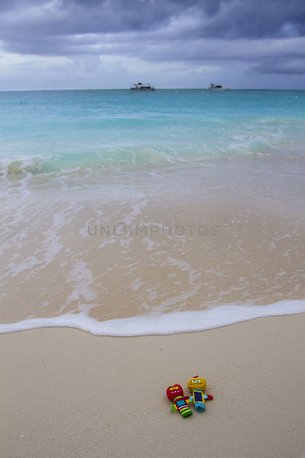 two colorful finger puppets on a sandy beach during a storm