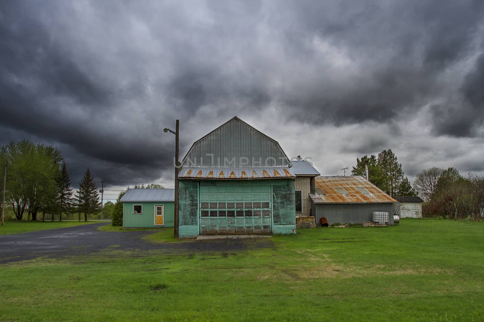 Green barn under dark storm clouds