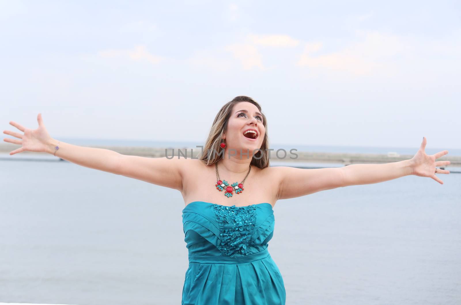 Happy woman with open arms looking at the sky