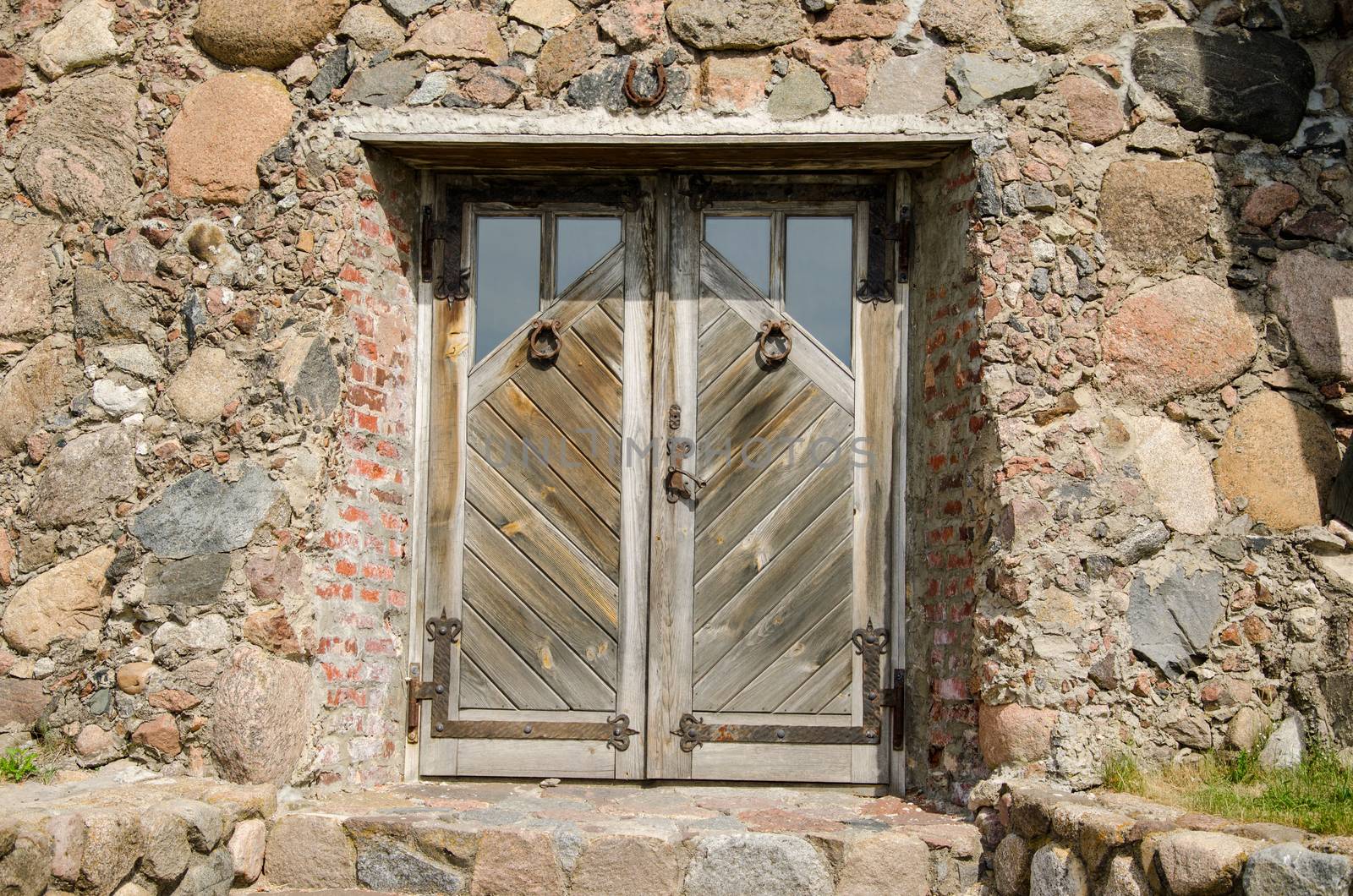 horseshoe hanging over stone wall building old wooden entrance door