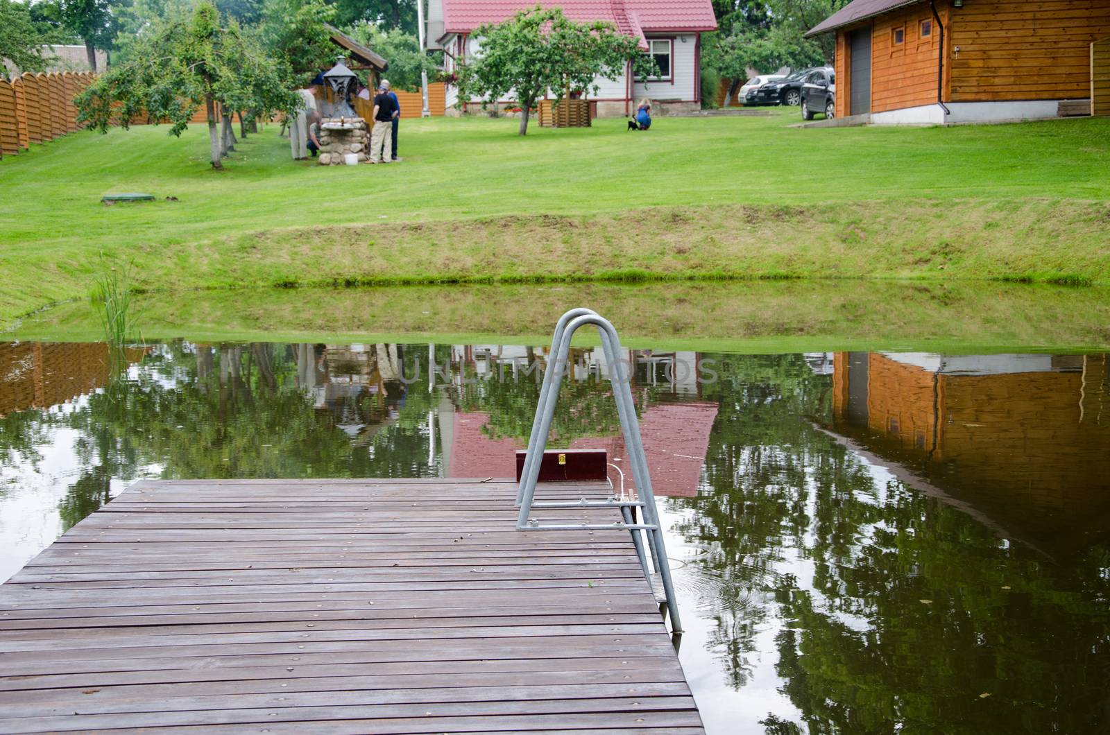 rural pond with large plank bridge village yard by sauletas