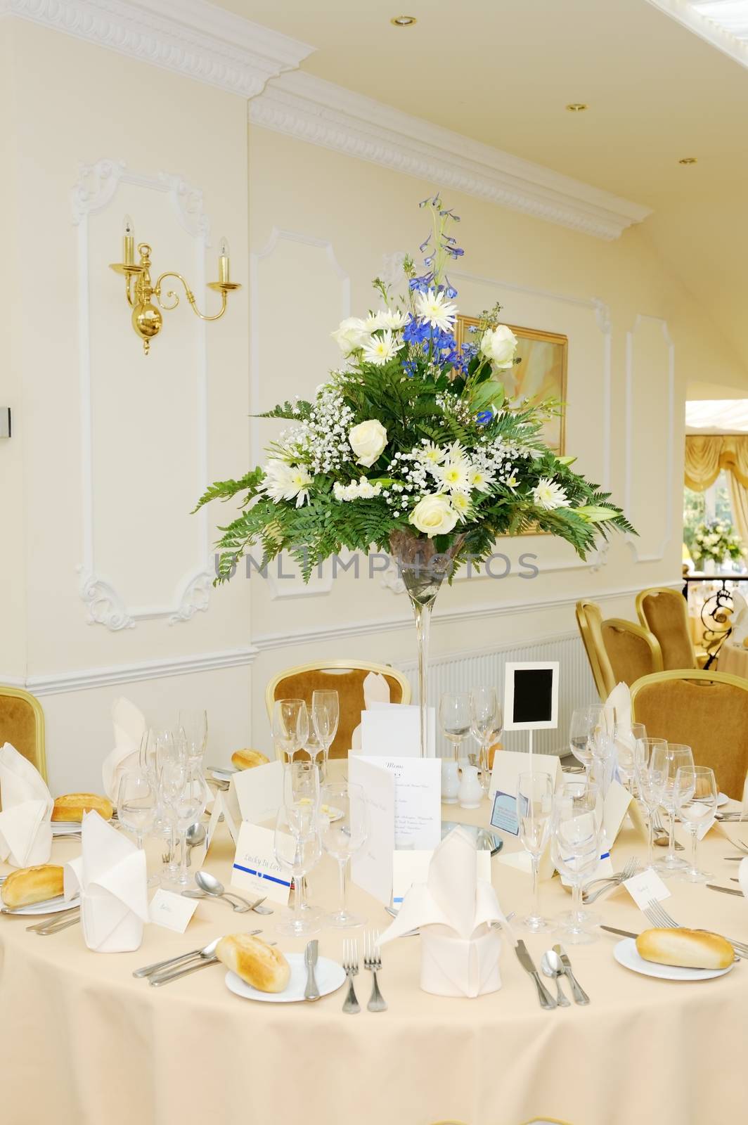 Weding reception table decorated with flowers with yellow tablecloth