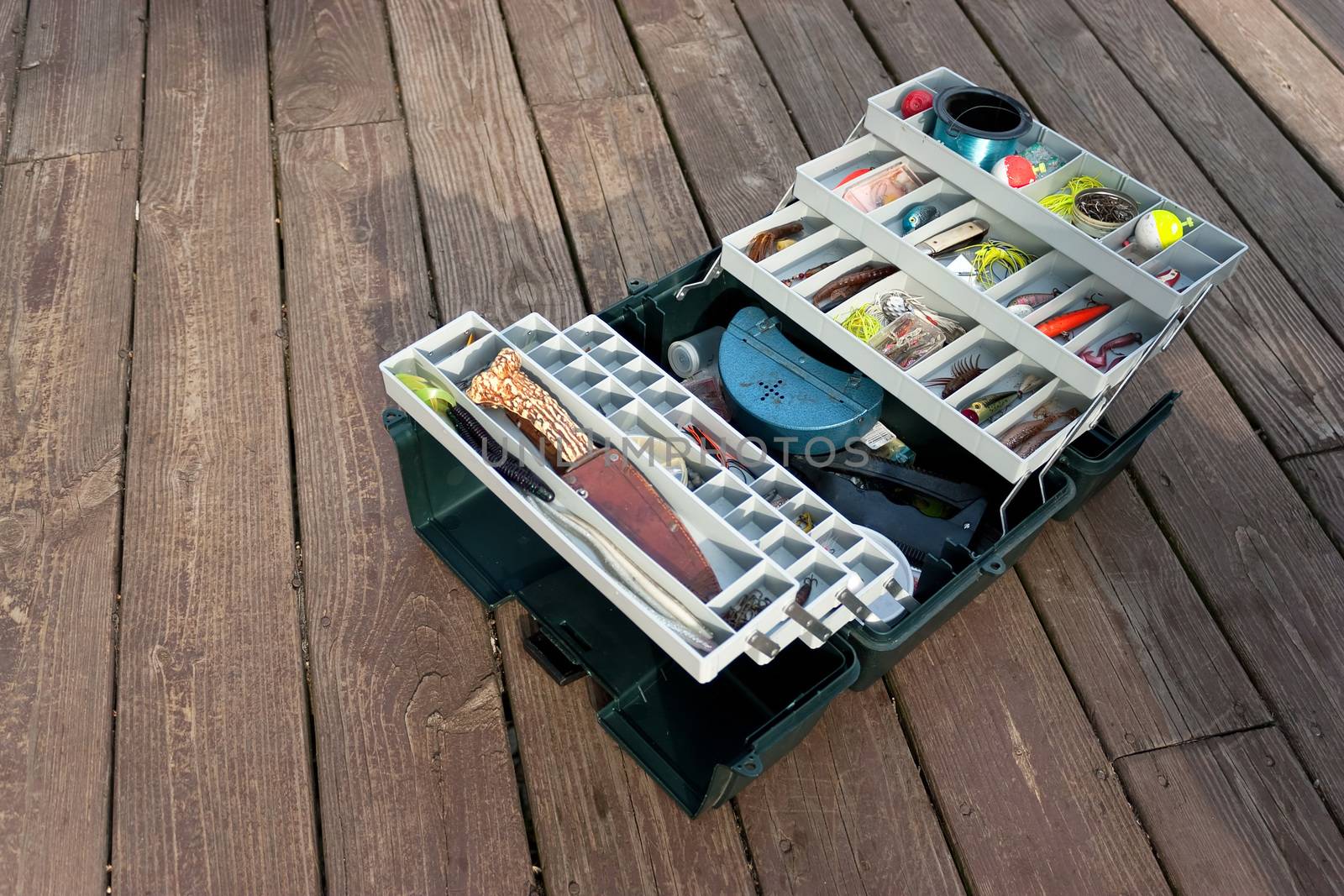 A large fishermans tackle box fully stocked with lures and gear for fishing.