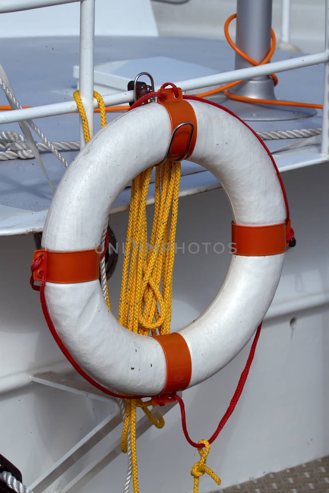 Life preserver and rope hanging from the railing of a boat