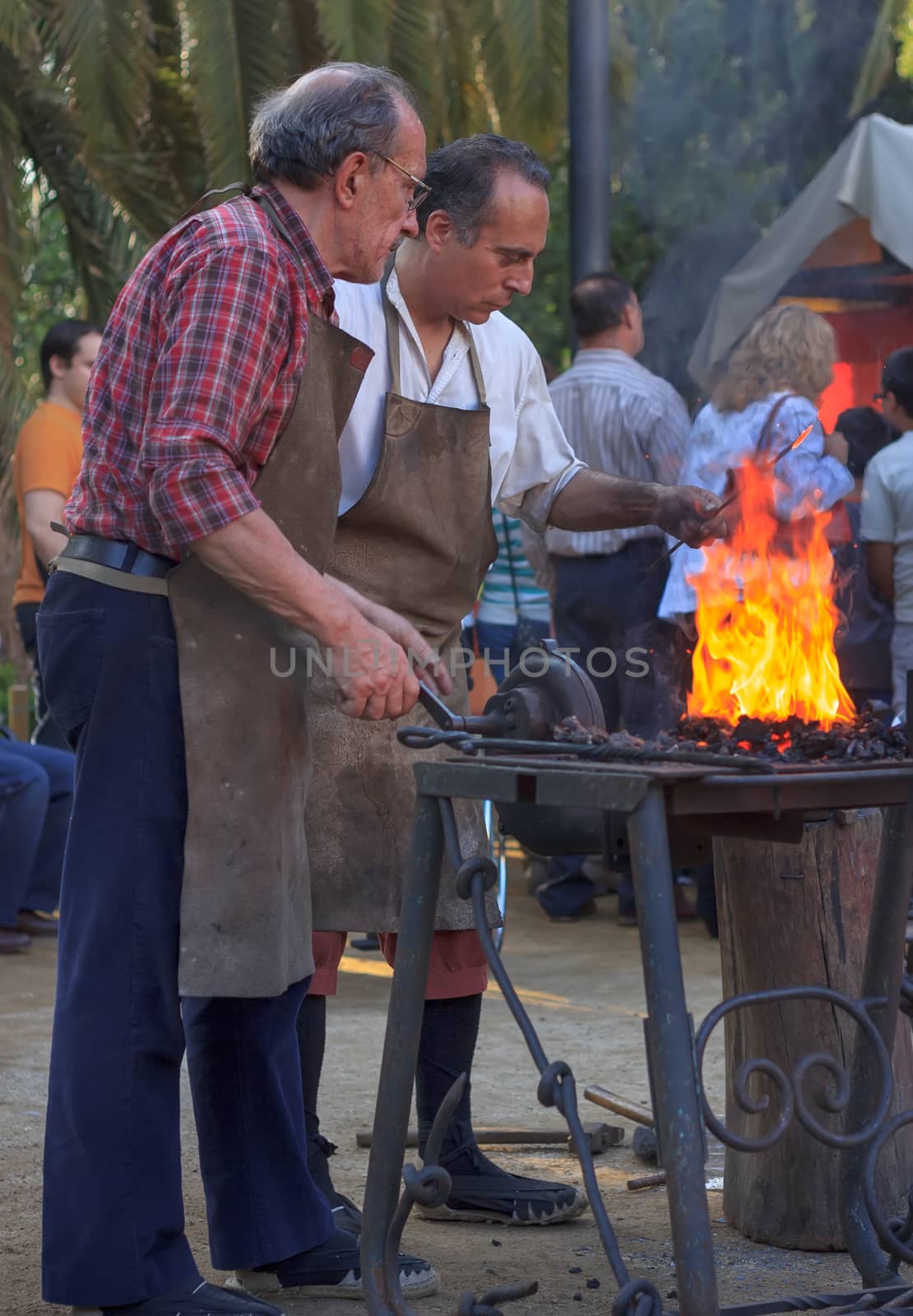 TARRASA, BARCELONA, SPAIN - MAY 08, 2011: Unidentified Blacksmiths working on metal  at forge in the modernist fair held every year in the city.