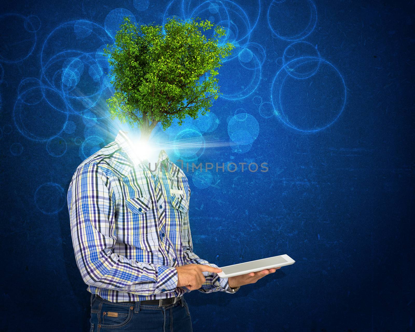 Man hold tablet pc. Green tree and bright light instead his head. Eco concept