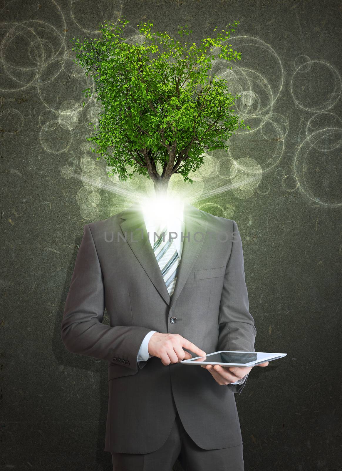 Businessman hold tablet pc. Green tree instead his head by cherezoff