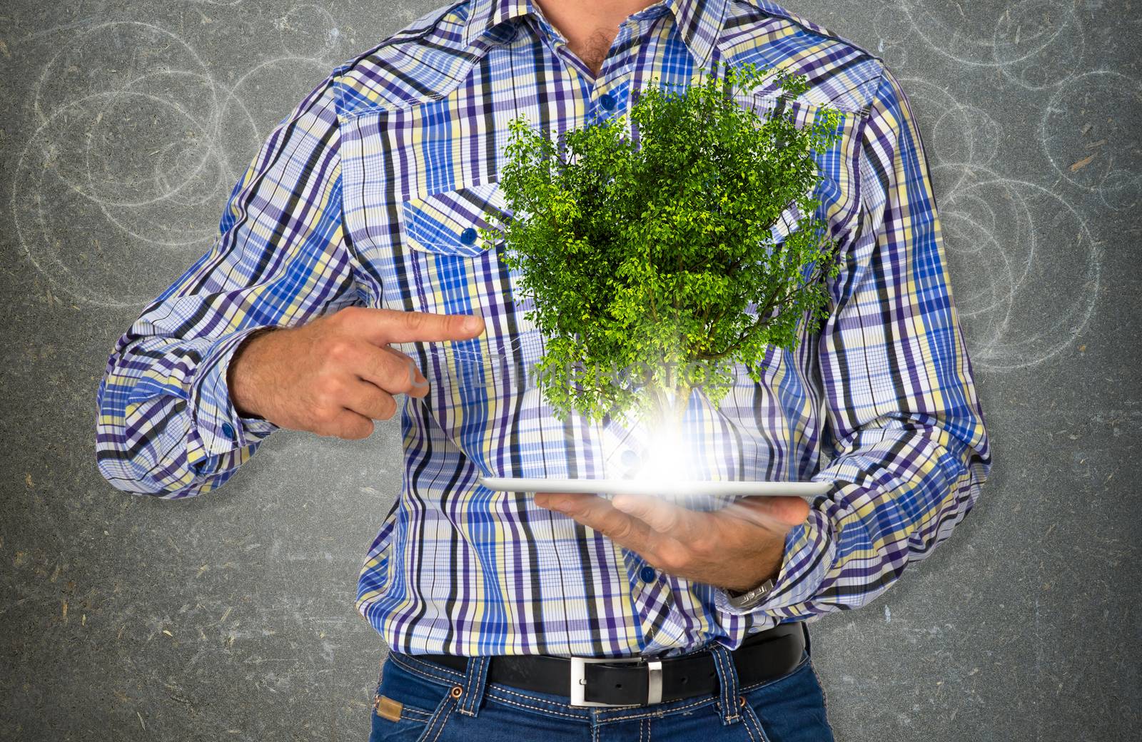 Man hold tablet pc with green tree and bright light. Eco concept