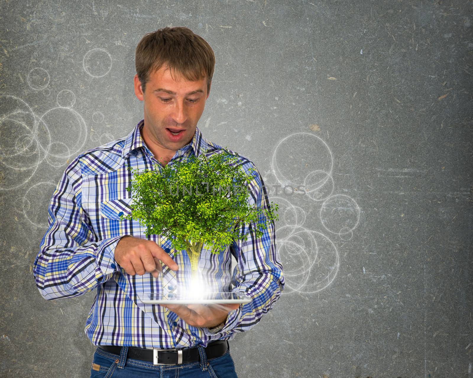 Man hold tablet pc with green tree and bright light. Eco concept