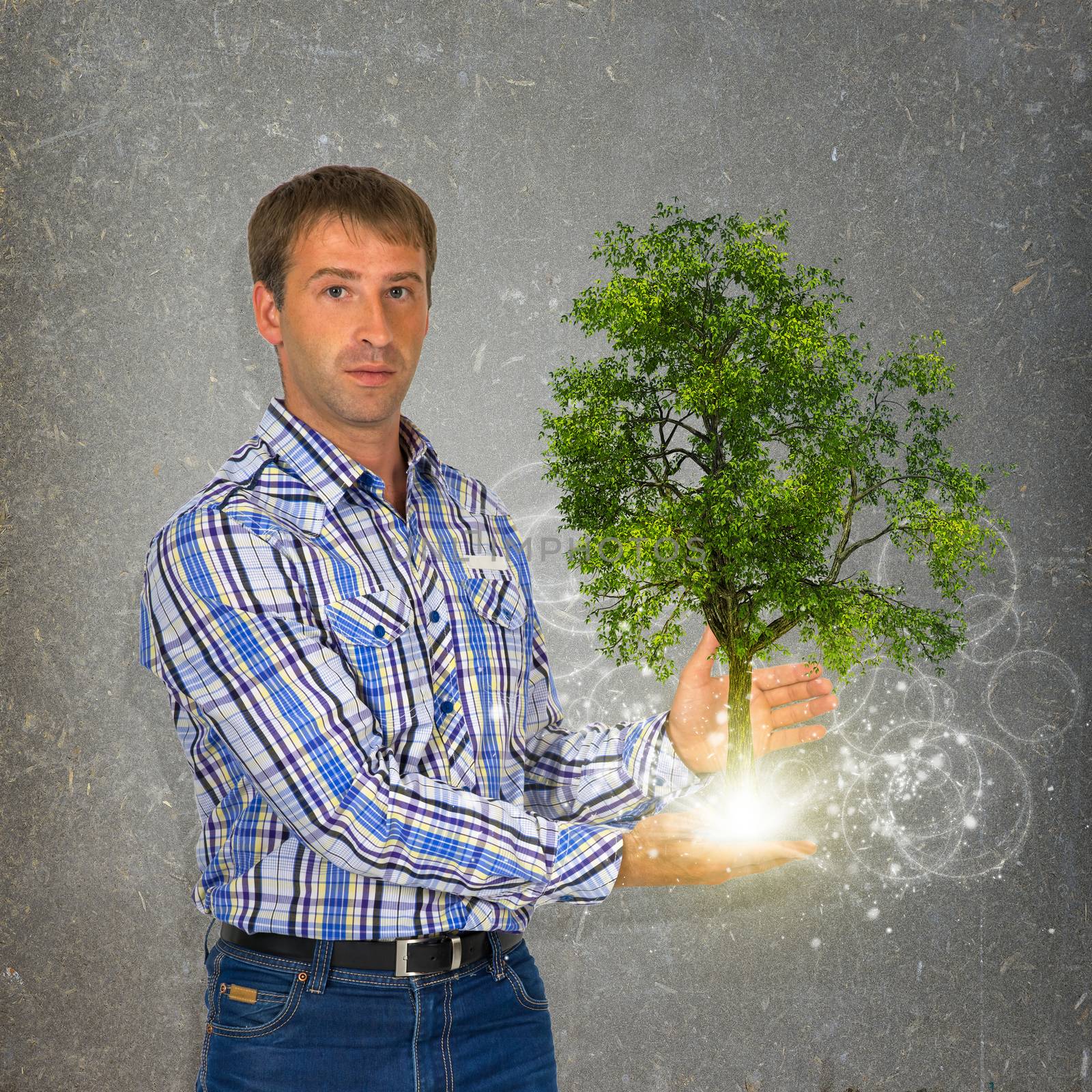 Man hold green tree and bright light. Eco concept