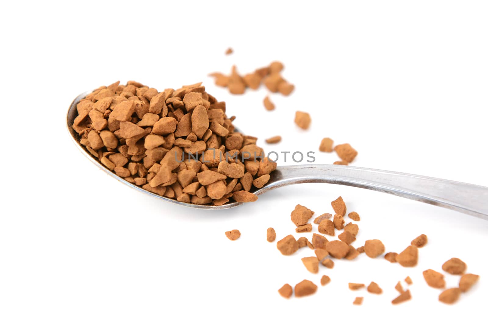 Closeup of a teaspoon of instant coffee granules, isolated on a white background