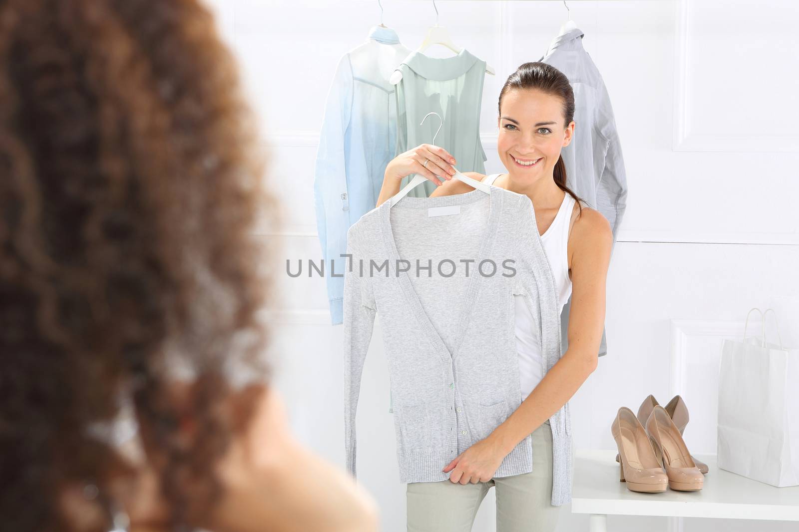 Two women shopping in boutique clothing, mulatto and Caucasian