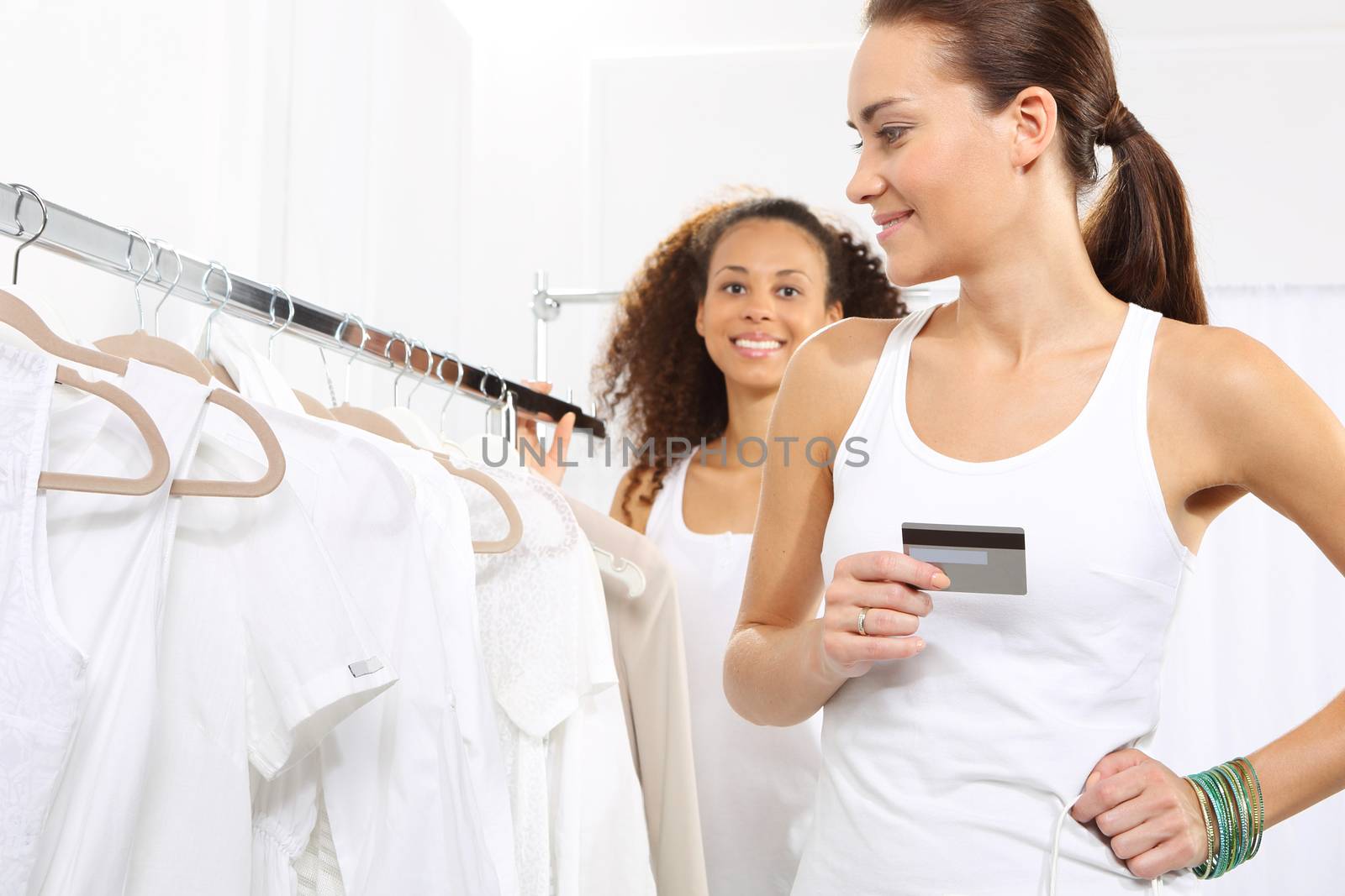 Woman in clothing store pay for purchases by credit card.