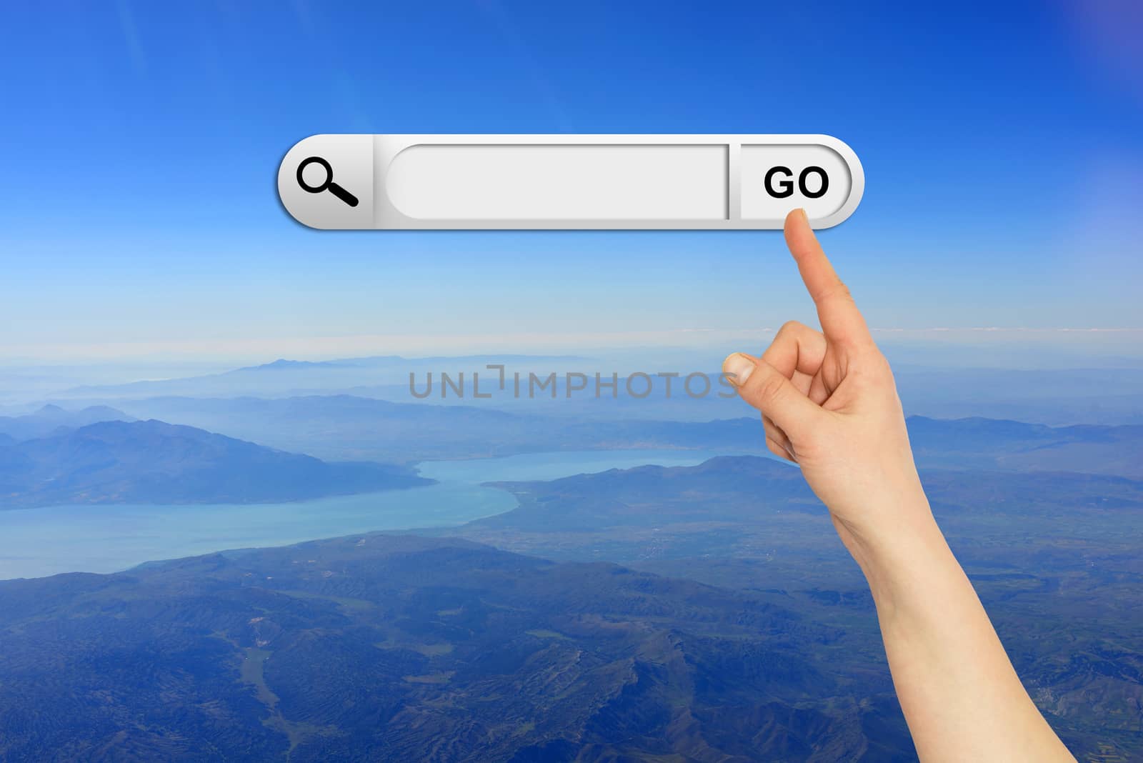 Human hand indicates the search bar in browser. Mountain, river and sky on background
