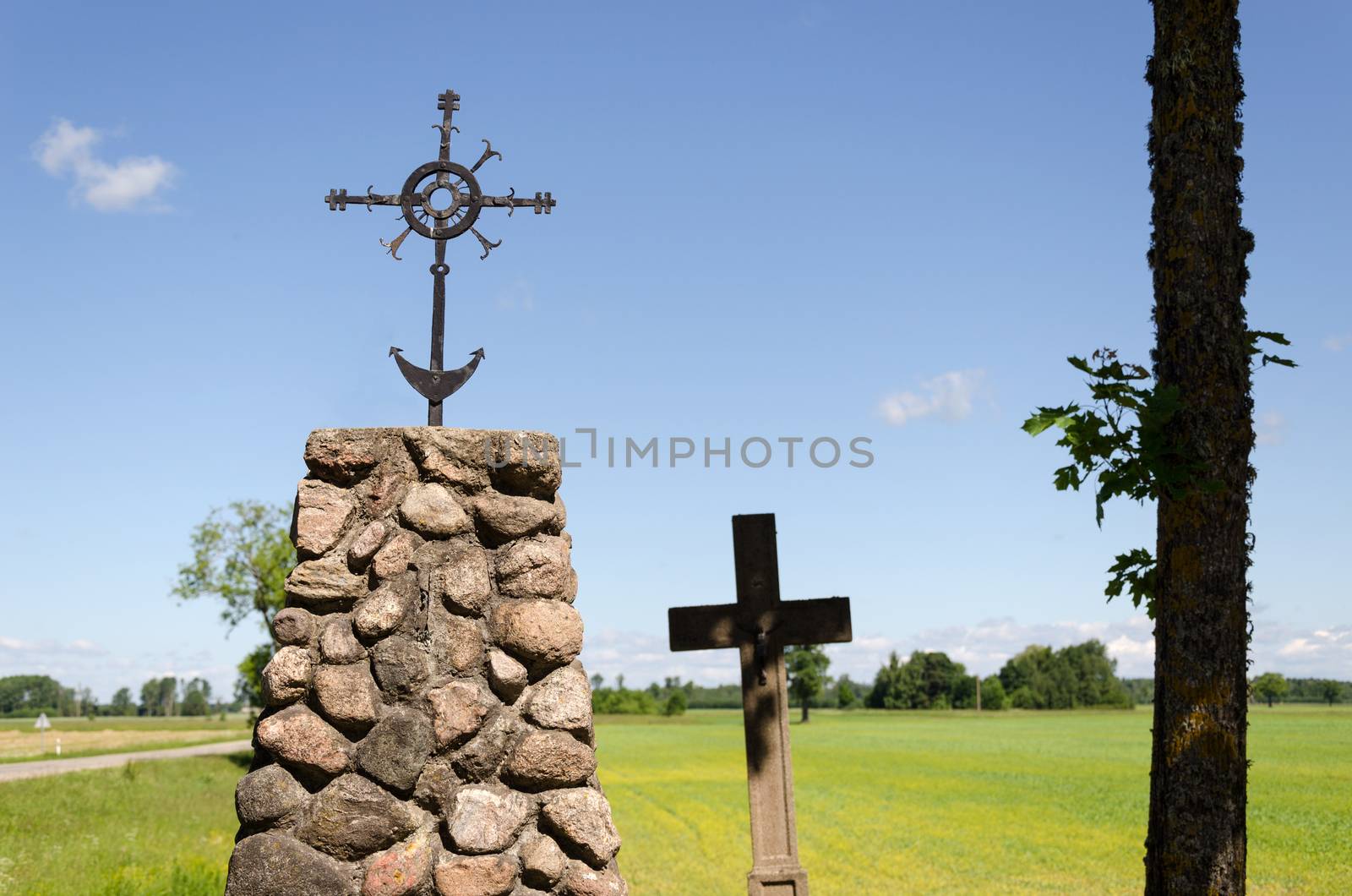 stone monument with metal ornament squirm cross in summer nature