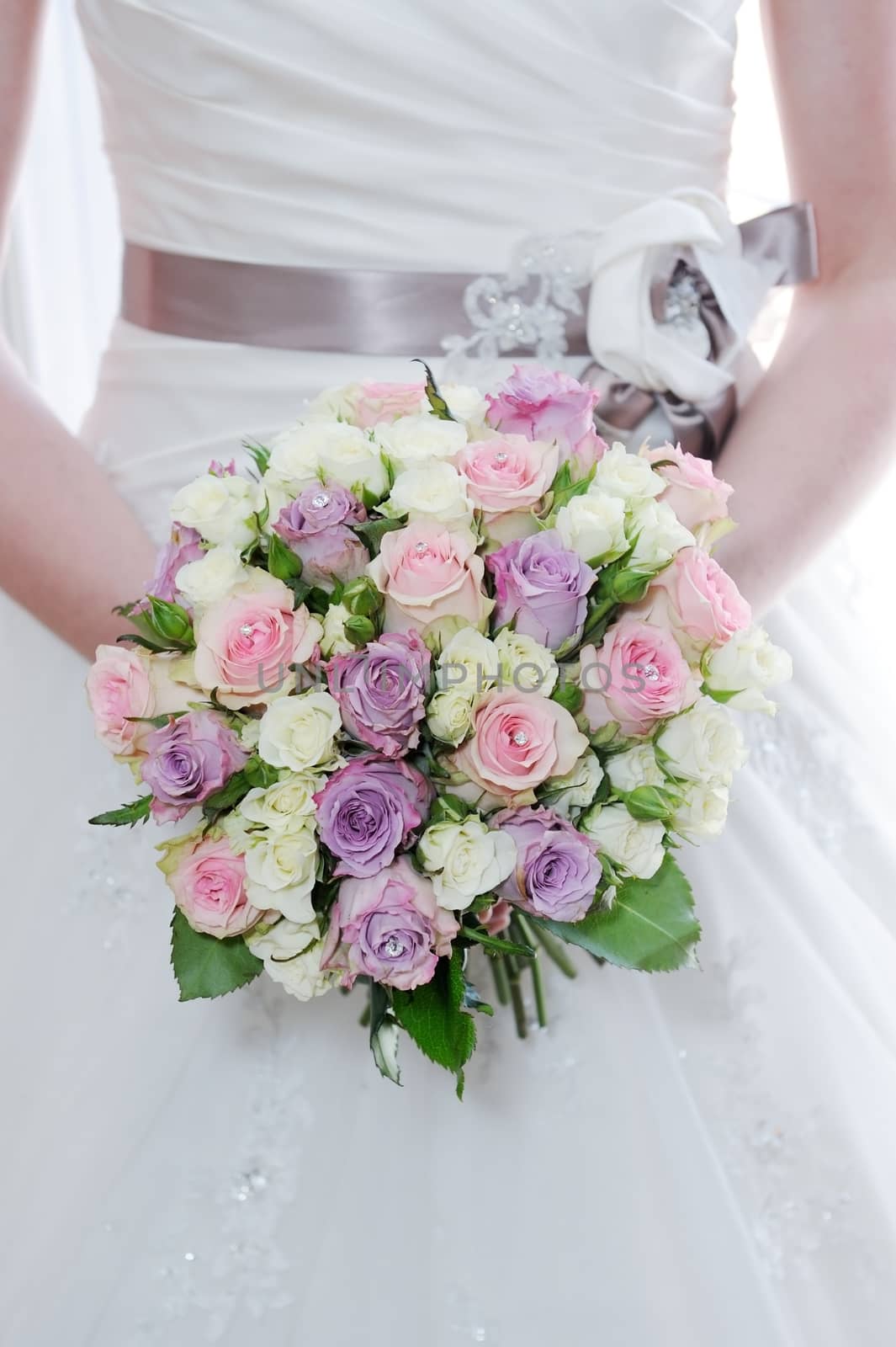 Brides bouquet of pink and purple roses closeup on wedding day