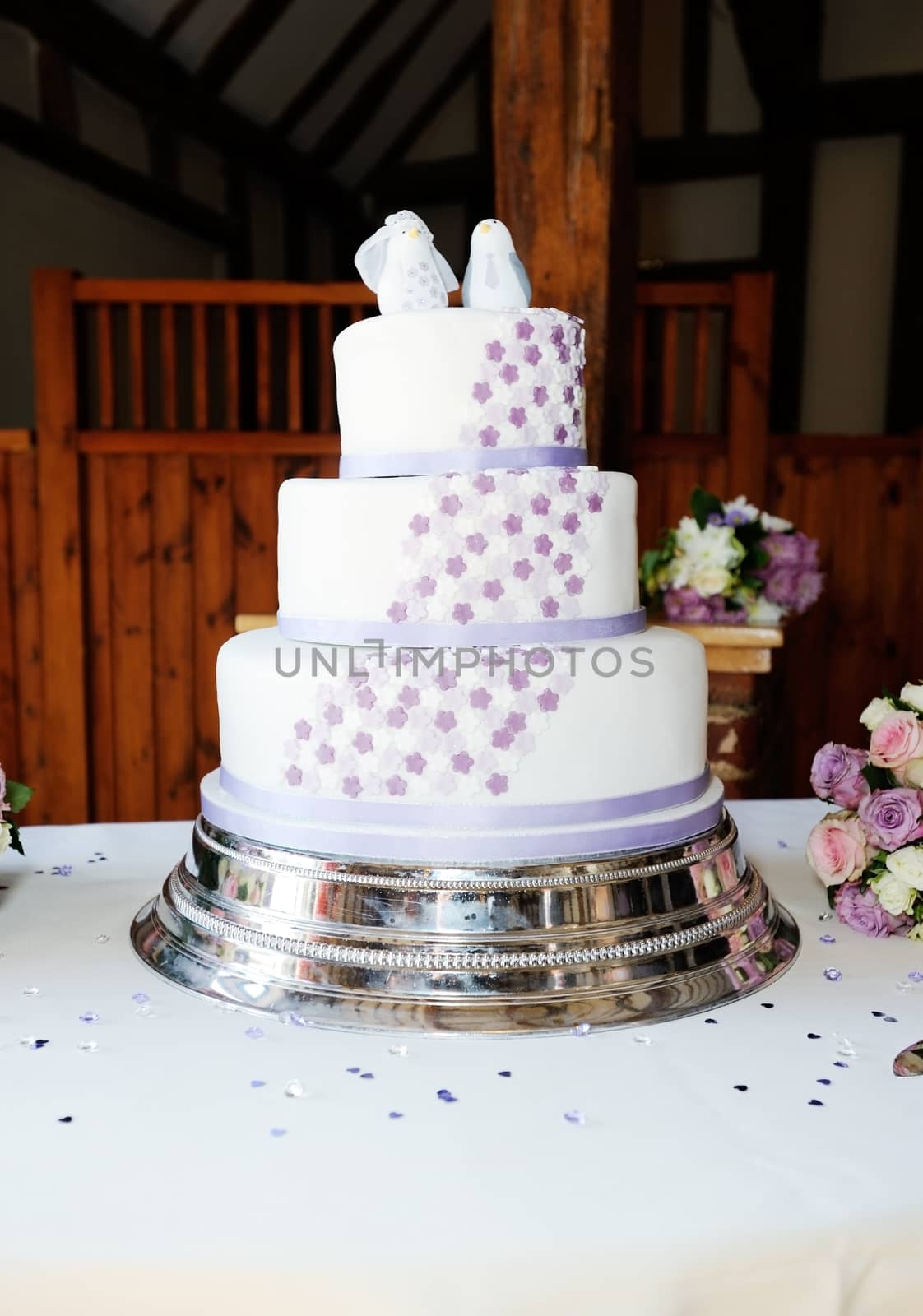 Wedding cake on table at reeption with brides flowers