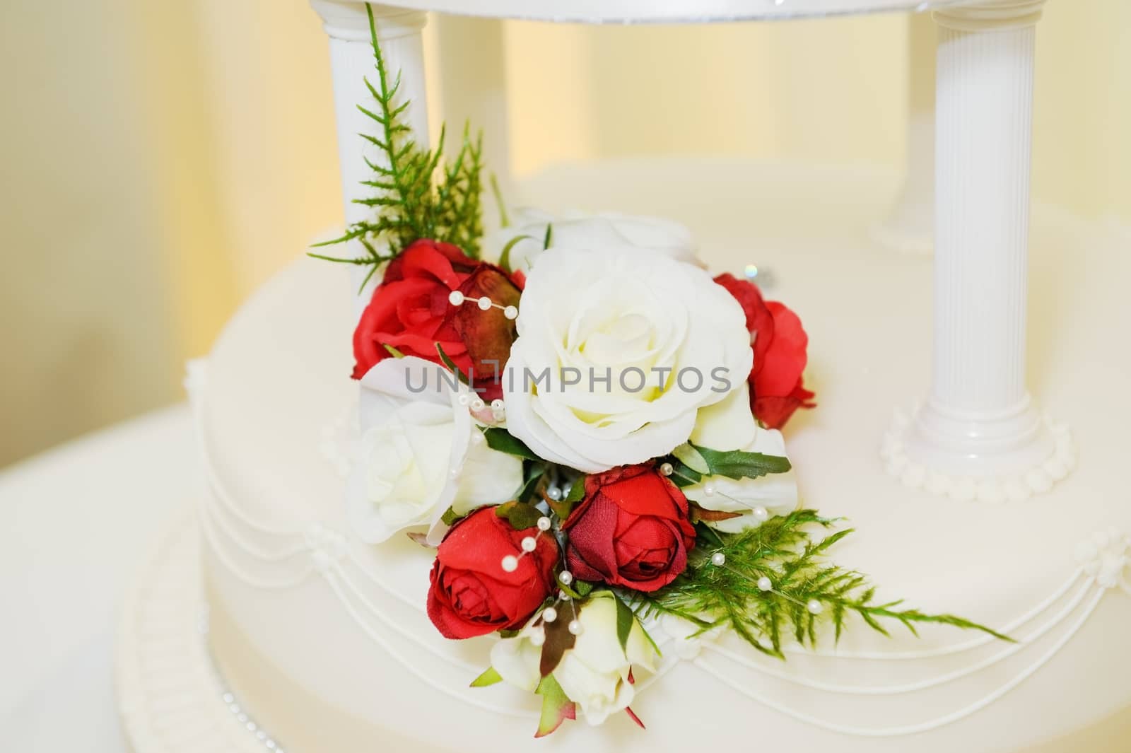 Wedding cake with red and white rose decoration closeup