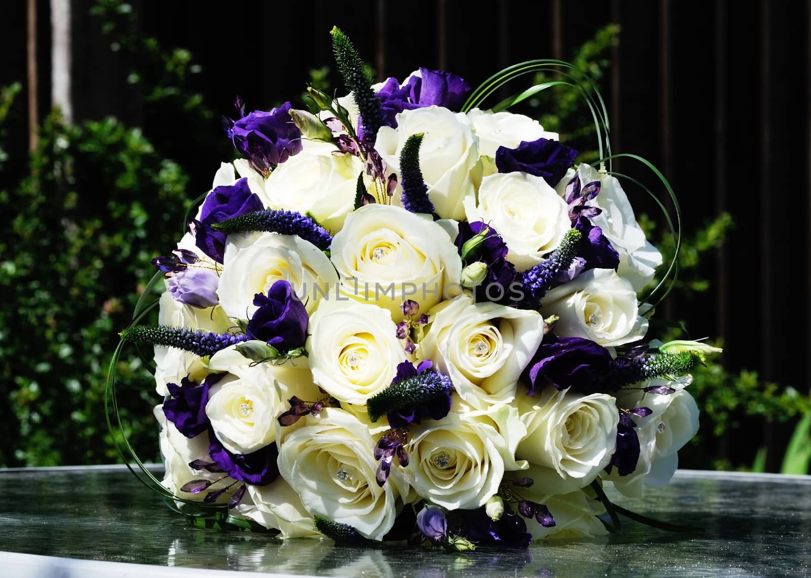 Brides arrangement of purple flowers and white roses on wedding day