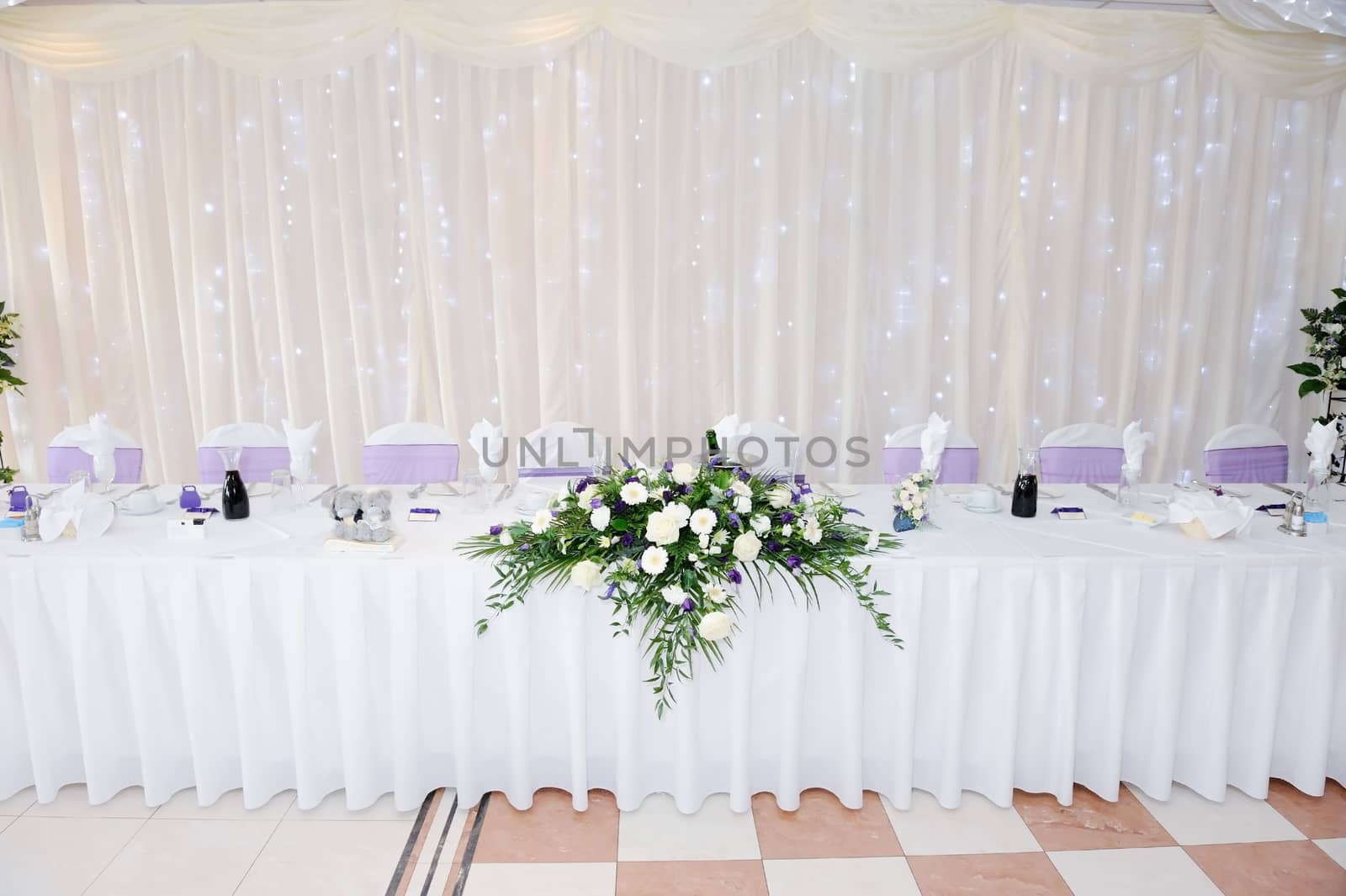 White and purple flowers decorate table at wedding reception