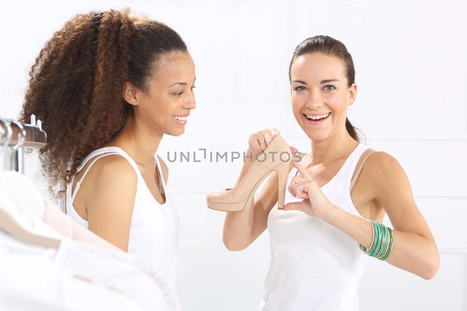 Women buy shoes at a shoe store, mulatto and Caucasian