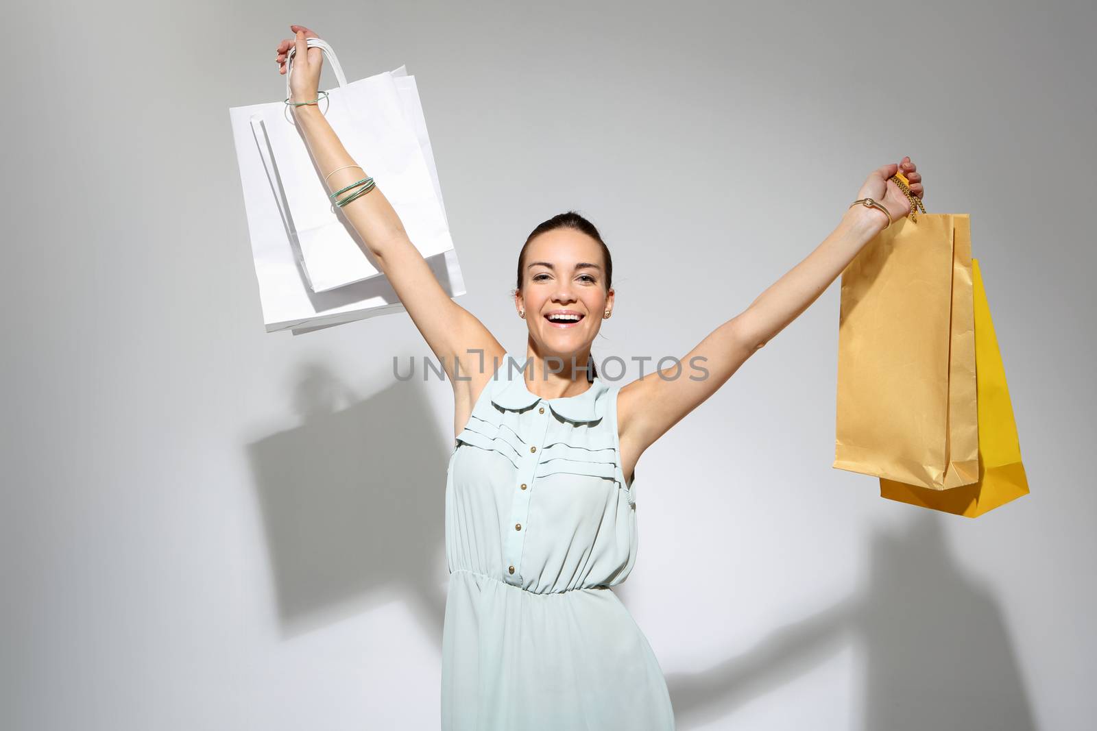 Young, attractive girl in a summer dress with a large bag purchasing