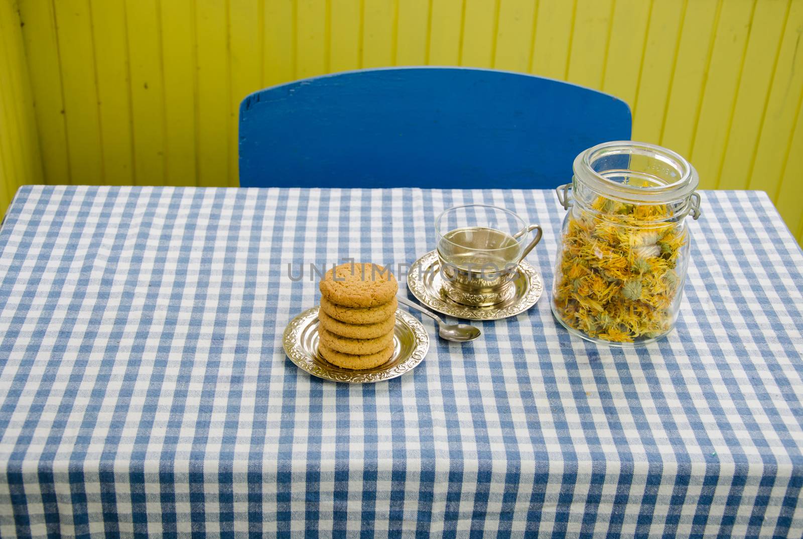 dried marigold dish with cup and cookies on table by sauletas