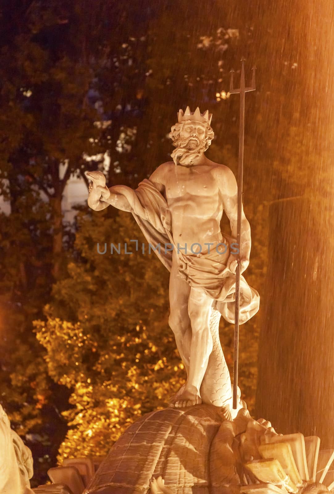 Neptune with Trident Snake, Roman God, Statue Fountain Night Plaza Canovas del Castillo Madrid Spain.  Neptune Statue designed in 1780 by Ventura Rodriguez as part of Carolos III's scheme to beautify Madrid, Spain.