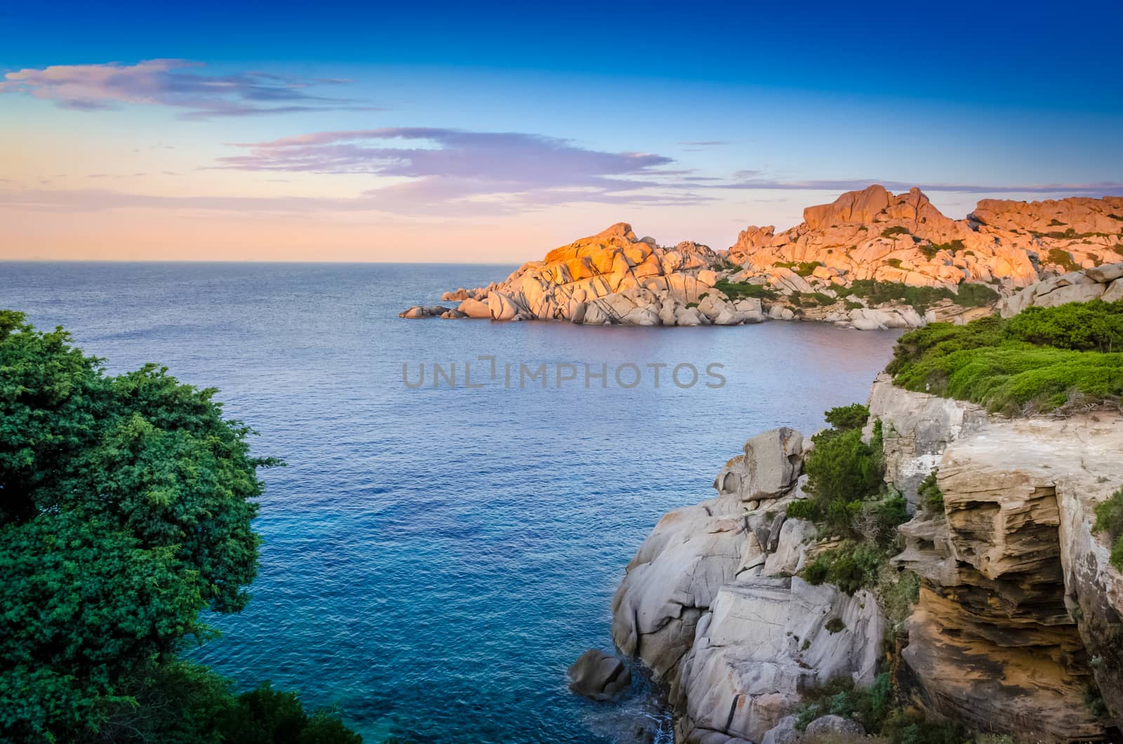 Ocean rocky coastline colorful sunset view, Sardinia, Italy