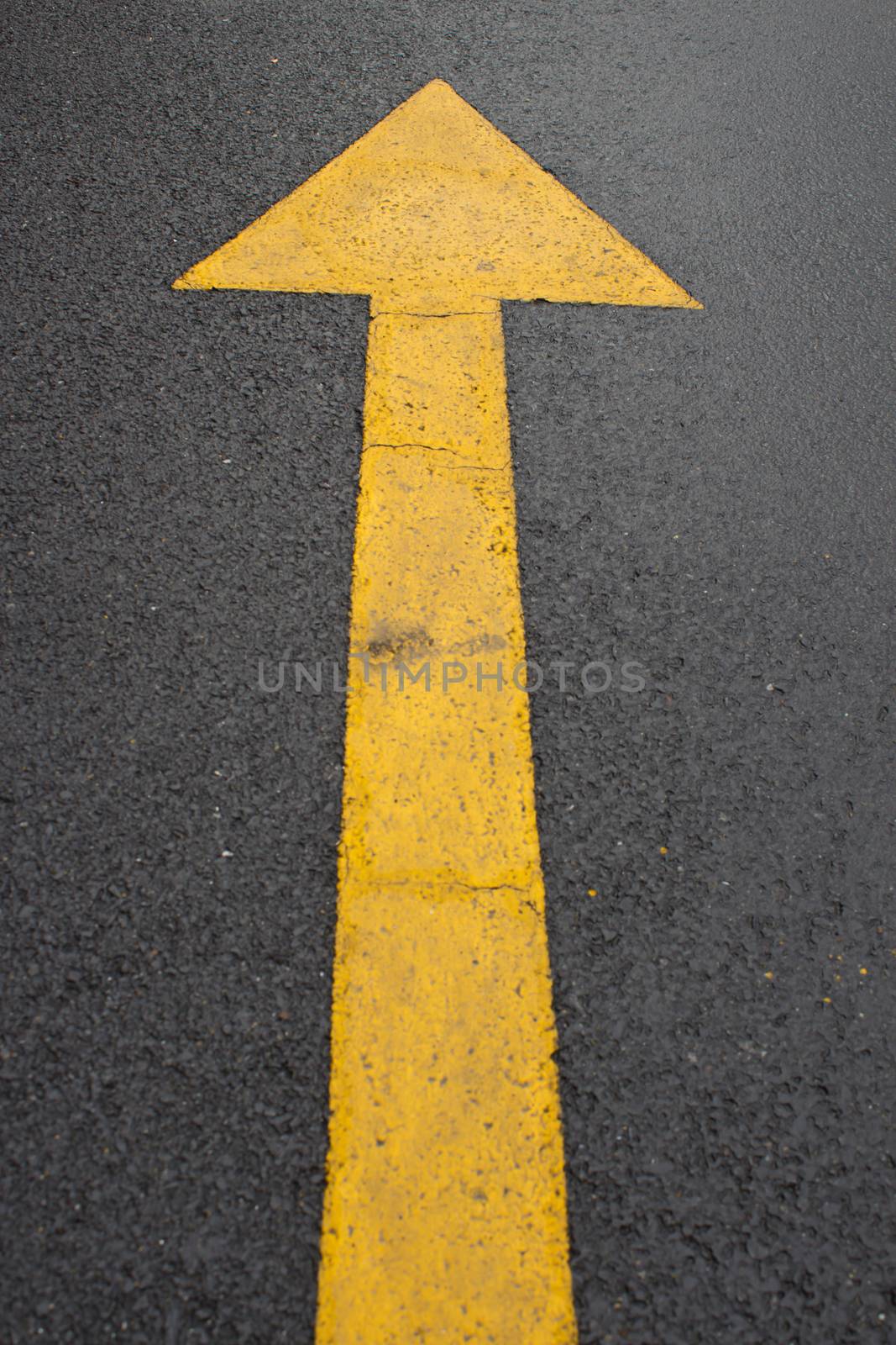 wet yellow arrow road or concept and slippery