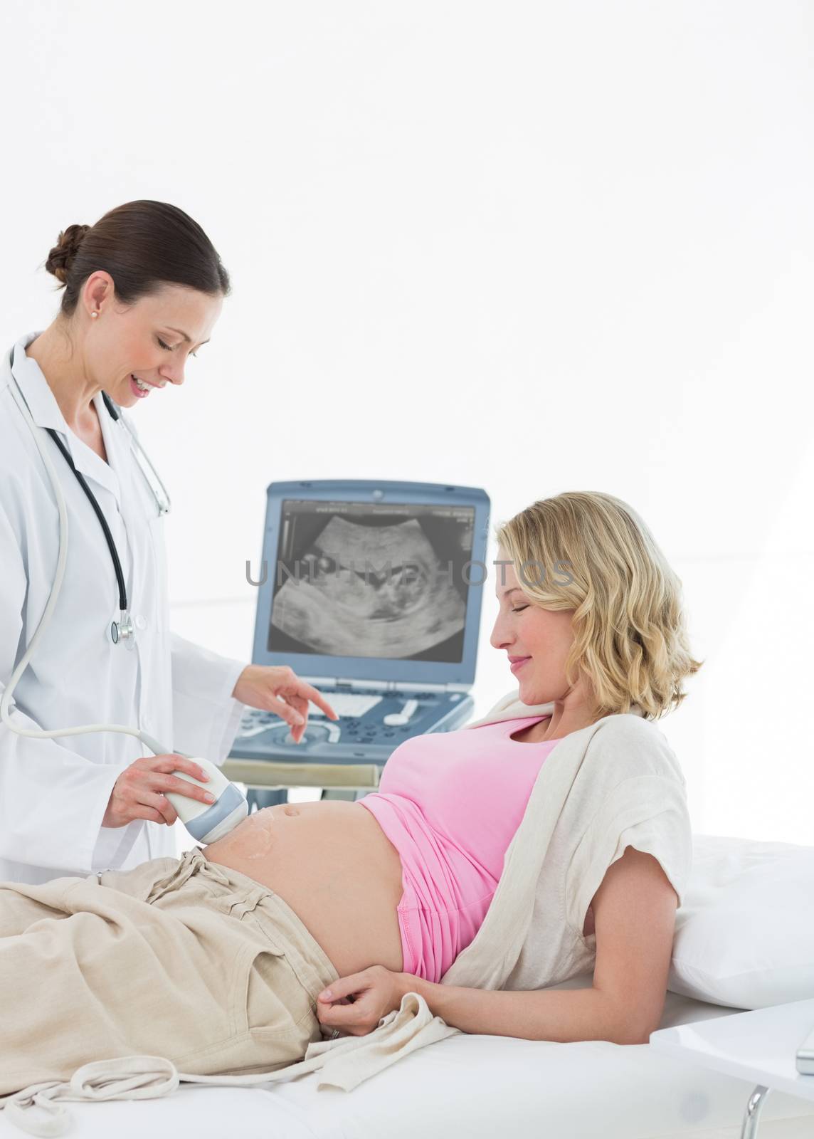 Doctor performing ultrasound on pregnant woman by Wavebreakmedia