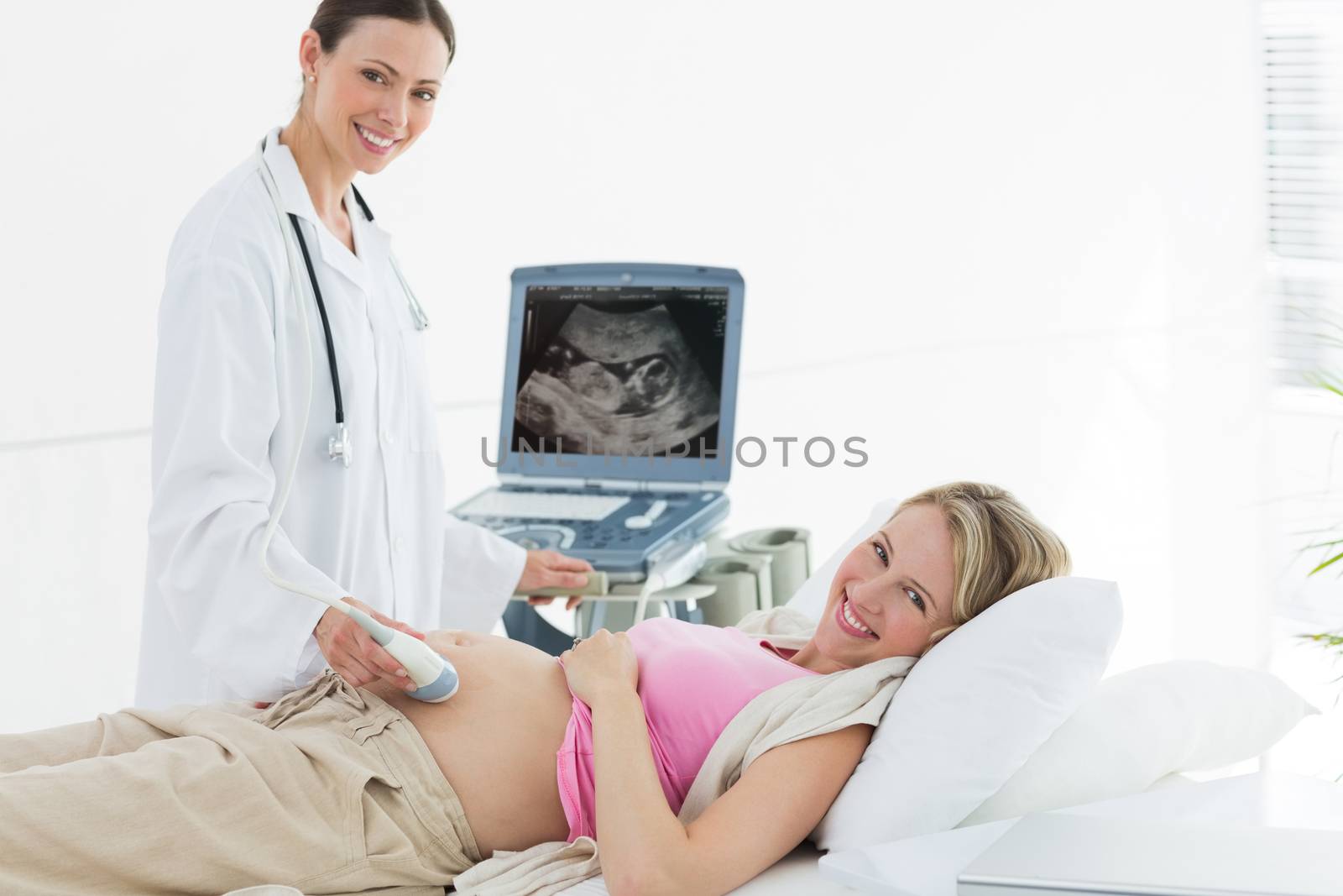 Doctor using ultrasound machine on pregnant woman by Wavebreakmedia