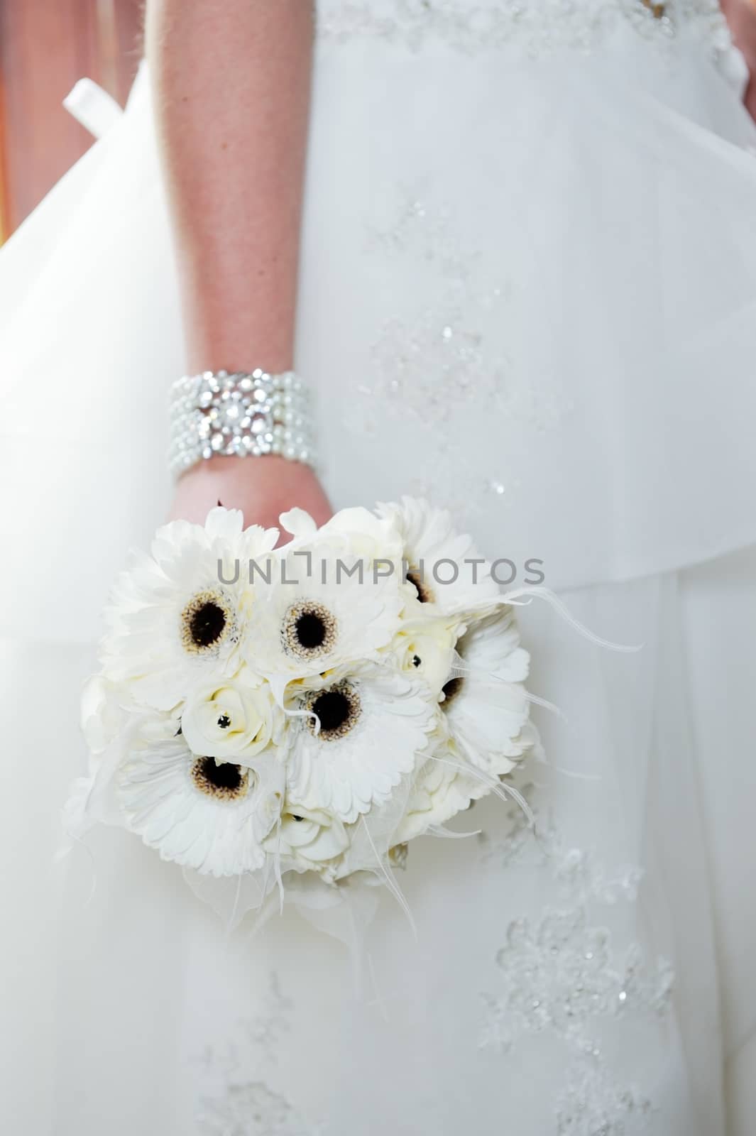 Bride holding white bouquet by kmwphotography