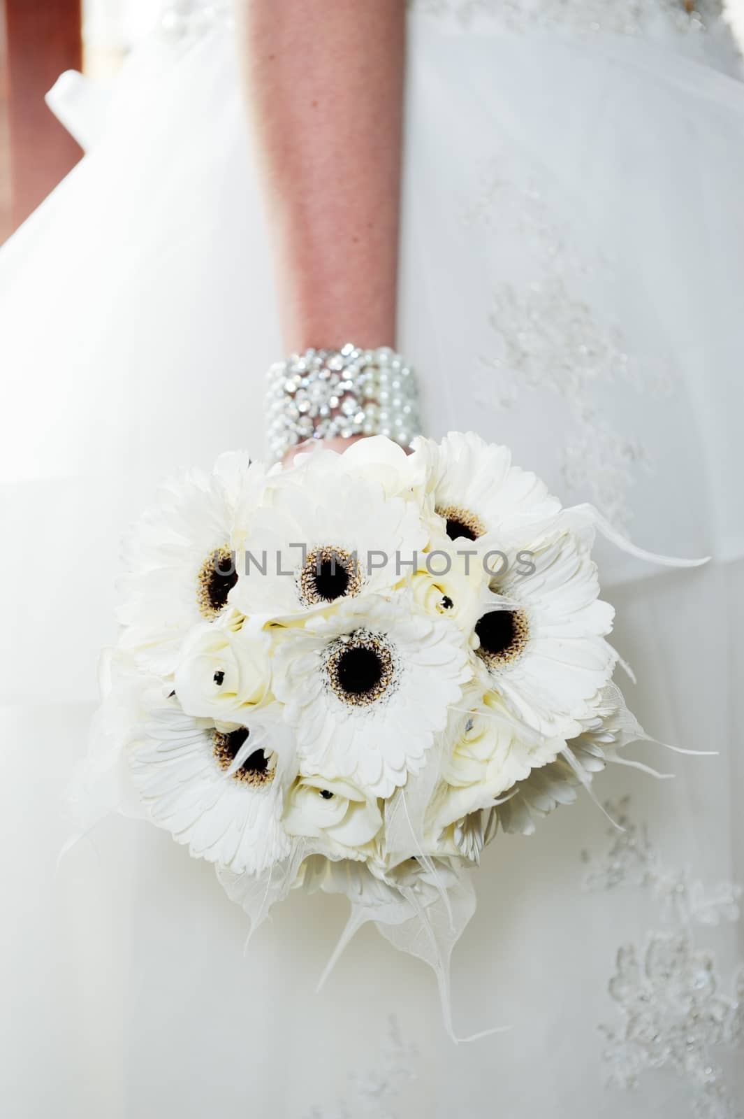 Closeup detail of bride holding white bouquet