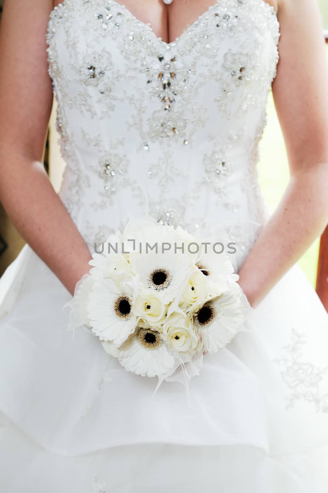 Brides white flower arrangement and dress detail closeup