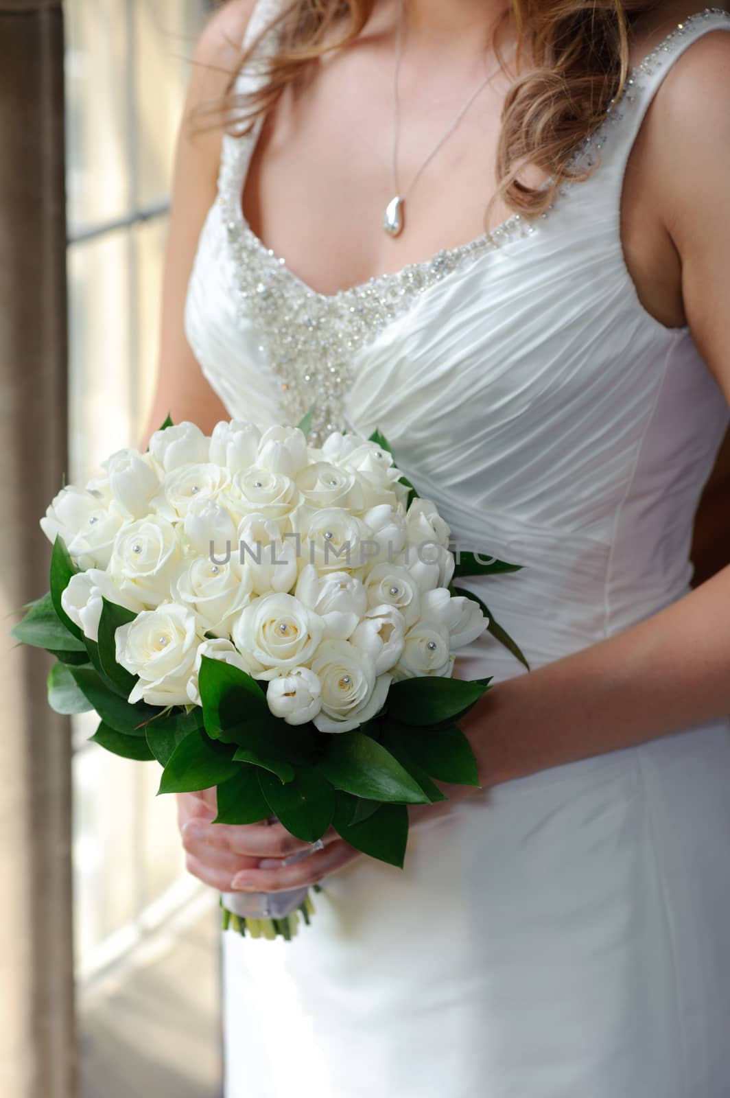 Bride holding white roses by kmwphotography