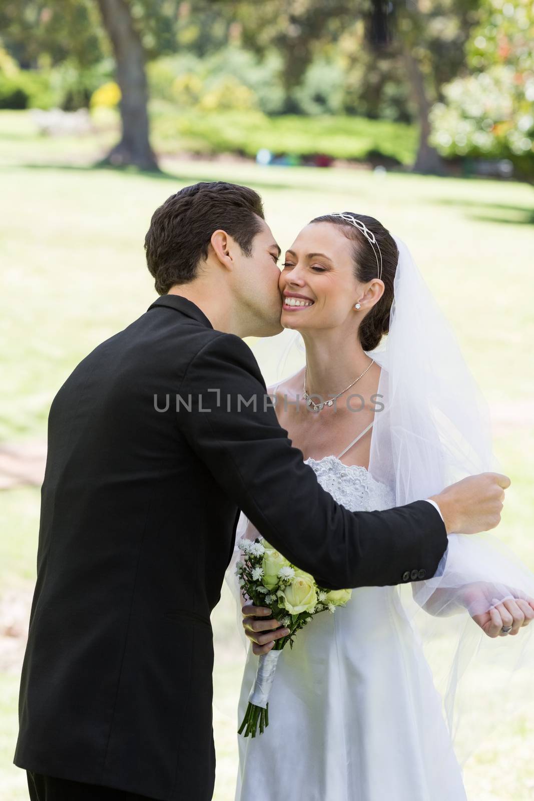 Groom kissing bride in garden by Wavebreakmedia